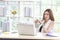 Portrait of beautiful Asian businesswoman sitting on chair, there are laptop and smartphone at her desk