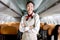 Portrait of beautiful Asian female cabin crew air hostess in uniform standing with arms crossed on aisle inside airplane, woman