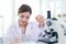 Portrait of beautiful Asian female scientist in lab coats doing science experiments, happy researcher woman using lab equipment