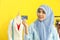 Portrait of beautiful asian muslim woman designer with hijab holding mockup fake credit card in her working studio room with