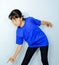 A portrait of a beautiful Asian woman crouching in a blue shirt greets a smiling face on the plaster floor.