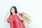 portrait of beautiful asian woman wearing red outfit gesturing carrying lots of shopping bags with happy expression