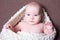 Portrait of beautiful baby girl in white woolen scarf