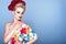 Portrait of beautiful blond model with updo hair and perfect bright make up wearing floral sundress and fluffy peony head garland