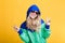 Portrait of beautiful blond woman in sunglasses and blue green hooded jacket on yellow background. hipster summer.