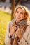 a portrait beautiful blonde in a coat with scarf on an autumn street.