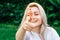Portrait of beautiful blonde girl smiling, making shot of fingers in camera with happy face. Creativity and photography concept