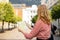 Portrait beautiful blonde woman with paper map in street. Happy tourist travels in Europe. Vacation concept by exploring