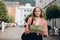 Portrait beautiful blonde woman with paper map in street. Happy tourist travels in Europe. Vacation concept by exploring