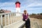 Portrait of a beautiful blonde woman sitting on a bench in front of Nauset Lighthouse on Cape Cod