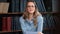 Portrait beautiful blonde woman wear eyeglasses posing at library bookshelves with positive emotion