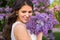 Portrait of beautiful bride with big bouquet of lilac flowers