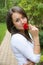 Portrait of beautiful brunette outdoors holding a red flower