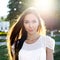 Portrait of a beautiful brunette in park in bright sunlight. Fashion style urban life, emotionally looks. Outdoor