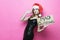 Portrait of a beautiful brunette woman in christmas hat holding and exquisite black dress a sign `Mad christmas ` shoots his finge