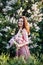 portrait of a beautiful brunette woman in a lilac dress with lilac flowers