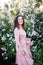 portrait of a beautiful brunette woman in a lilac dress with lilac flowers