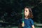 Portrait of a beautiful caucasian girl blowing soap bubbles while standing in a park