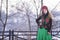 Portrait of Beautiful Caucasian Girl in Fashionable Green Dress and Kokoshnik with Flowery Pattern and Beads. Posing in Winter