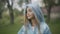 Portrait of beautiful Caucasian girl standing in raincoat outdoors and looking away. Unhappy schoolgirl on rainy summer