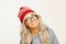 Portrait of beautiful caucasian woman with long blond hair, wears round spectacles, red cap, has a cute smile, isolated