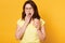 Portrait of beautiful charismatic young female holding papercup with coffee, covering mouth while yawning, closing eyes. Brunette