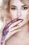 Portrait of beautiful curly blondy woman with colorful perfect art make-up, trendy frosted nail design with glitter