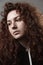 Portrait of a beautiful curly girl on a gray background