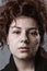 Portrait of a beautiful curly girl on a gray background