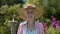 Portrait of a beautiful elderly woman in her garden enjoying retirement.