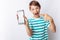 Portrait of a beautiful and emotional boy, in whose hands a broken phone shows surprise, white background, blue t-shirt, advertisi