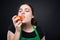 Portrait of beautiful employee eating nectarine with pleasure