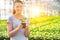 Portrait of beautiful female botanist holding seedling in plant nursery