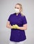 Portrait of beautiful female nurse, beautician, cosmetologist or worker of beauty industry posing in uniform and protective mask