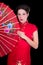 Portrait of beautiful geisha in red japanese dress with fan