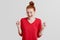 Portrait of beautiful ginger woman clenches fists, rejoces success, dressed in red sweater, isolated over white background. Attrac