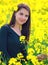 Portrait of a beautiful girl in the colza field