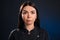 Portrait of a beautiful girl on a dark blue background, which with a serious face