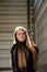 Portrait of a beautiful girl in a dark red dress knee-deep and in a dark leather jacket in the street in the afternoon background