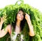 Portrait of a beautiful girl with hair from green branches of Japanese larch. Close-up.