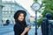 Portrait of a beautiful girl in a hat in summer. image of a hipster girl in the city, against the background of a large clock with