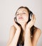 Portrait of beautiful girl in headphones, listening music, singing a song on white, lifestyle people concept