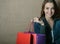 Portrait of beautiful girl holding colored shopping bags