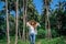 Portrait of a beautiful girl in the jungle in a straw hat and sunglasses, in the summer against a backdrop of palm trees