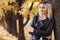 Portrait of a beautiful girl leaning on a tree trunk, a young woman walks in the autumn park on nature