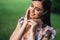 Portrait of beautiful girl in summer dress posing of greenery on background