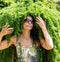 Portrait of a beautiful girl in sunglasses with hair from green branches of Japanese larch. Forest Nymph.