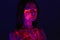 Portrait of beautiful girl with ultraviolet paint on her face. Girl with neon make-up in color light