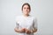 Portrait of beautiful girl in white t-shirt frowning her face in displeasure, keeping arms folded.