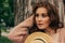 Portrait of a beautiful girl who stands near a tree. summer, walk in nature, red-haired girl in a vintage dress and a beige sweate